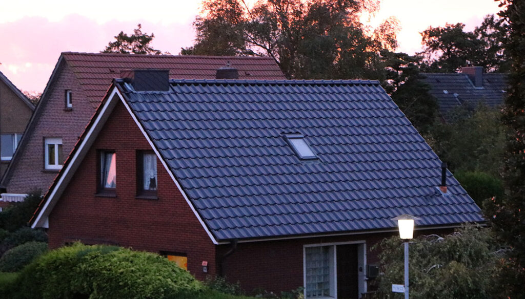 Das Bild zeigt ein gemütliches, verklinkertes Einfamilienhaus in der Dämmerung.